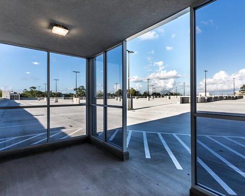 Photo through the glass windows/doors exiting out to the top floor of the parking structure.